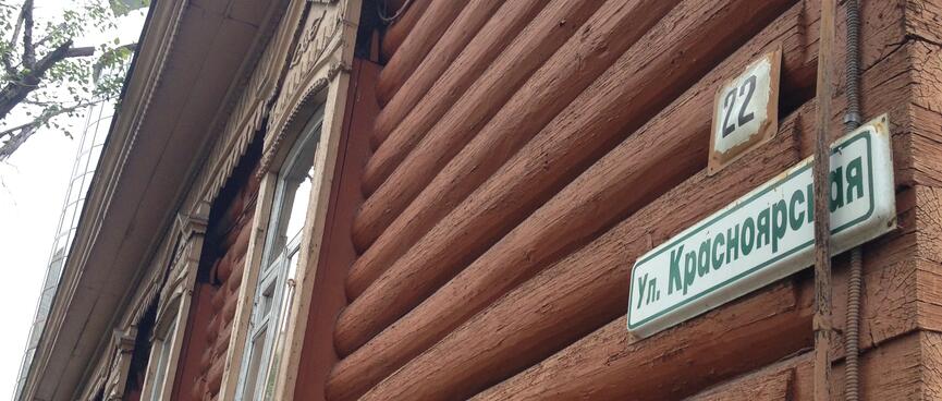 Wooden half-rounds cover the wall of an ancient log cabin, in Chita.