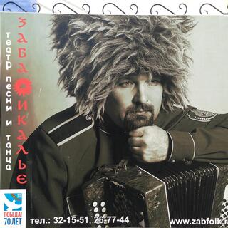 A man rests his chin on an accordion while wearing a tall fluffy hat.