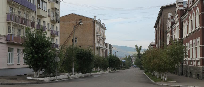 Three story apartment blocks line a deserted street, in Chita.