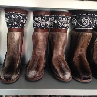 A shelf of brown fur boots look like horse legs.
