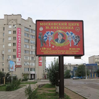 A bear on a bicycle, dark skinned dancers, and women with fancy head dresses and floral wings.