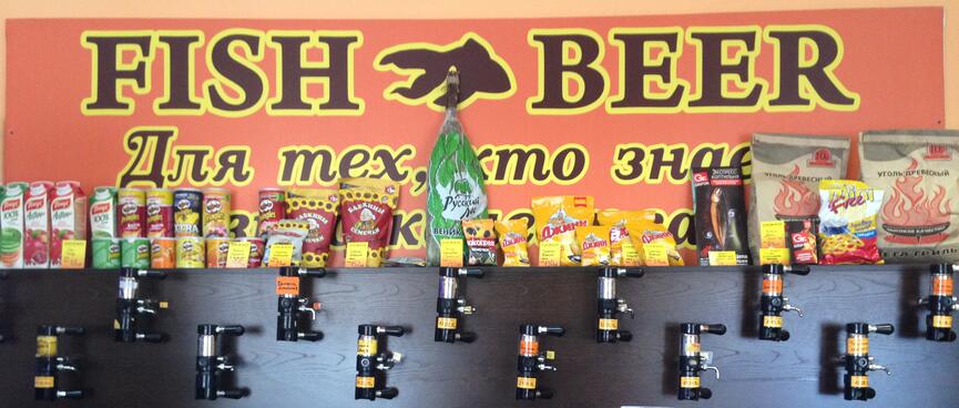 Beer taps cover a wall under a large sign stating FISH BEER, in Chita.