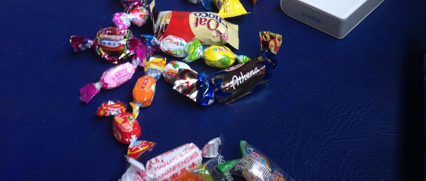 Wanna sits next to a large pile of candy.
