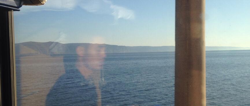 A wide blue lake is ringed in mountains.