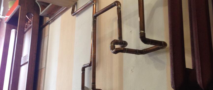 Curved bronze piping adorns the restaurant wall.