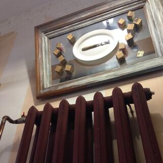 An artwork contains a dinner plate, a fork, and many small cubes.