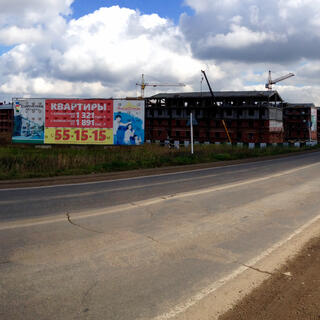Half-finished townhouses are surrounded by empty fields and older bungalows.