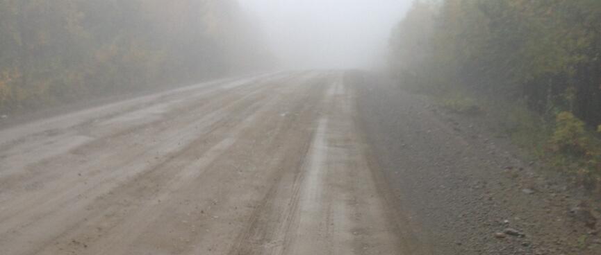 Riding into the mist on a hard packed dirt track.