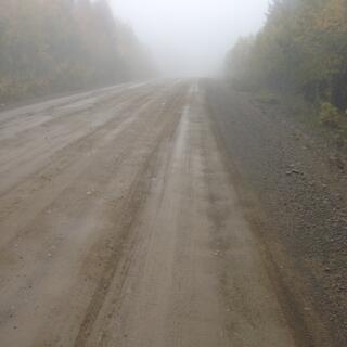 Riding into the mist on a hard packed dirt track.