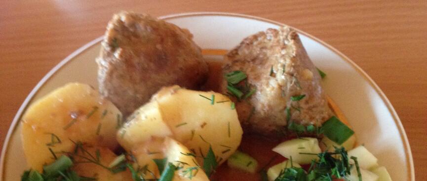 Meatballs, potatoes, and tomato and cucumber salad.