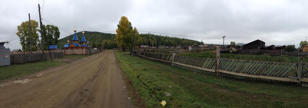 A wooden church in Maloye Goloustnoye has blue towers and golden domes.