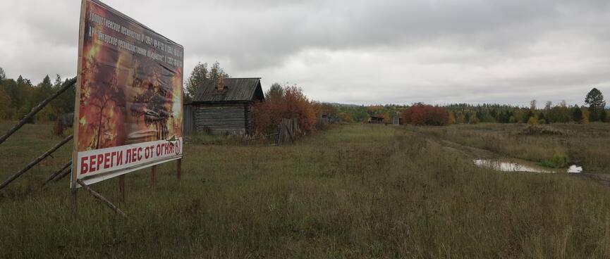 An advertising board shows flames engulfing the forest.