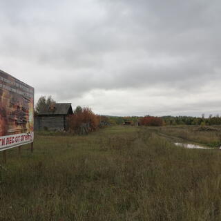 An advertising board shows flames engulfing the forest.