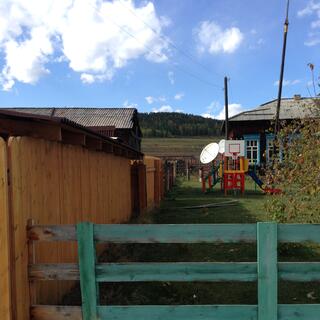 A plastic playground with slide and basketball hoop, and behind it two satellite dishes.