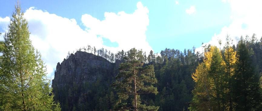 A narrow rocky ridge looms above the winding road.
