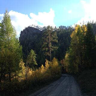 A narrow rocky ridge looms above the winding road.