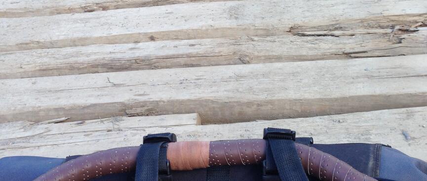 Holes in the cross beams of a wooden bridge.