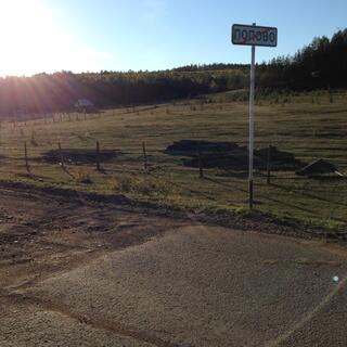 A dirt road abruptly changes to tar seal.