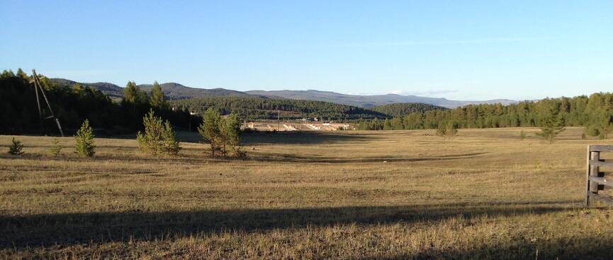 Rolling green fields and a distant village.