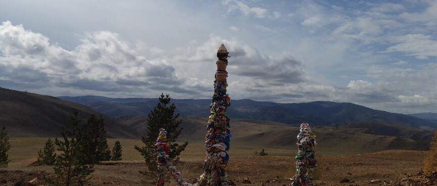A trio of wooden poles wrapped in ribbons.