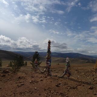 A trio of wooden poles wrapped in ribbons.