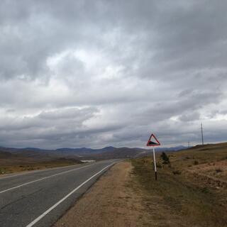 A road sign indicates a steep descent.