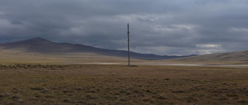 A lonely pole in a barren moody landscape.