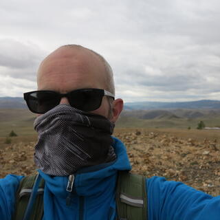 I pose in front of a rocky foreground and hilly background.