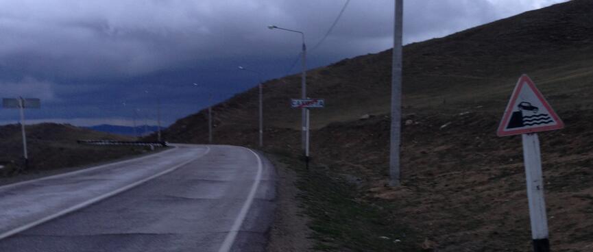 A road sign shows a car driving into the lake.