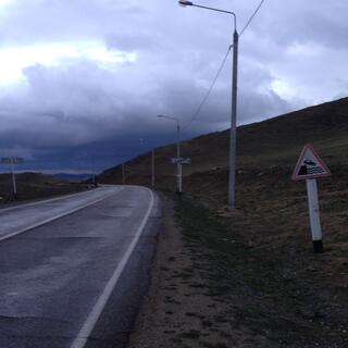 A road sign shows a car driving into the lake.