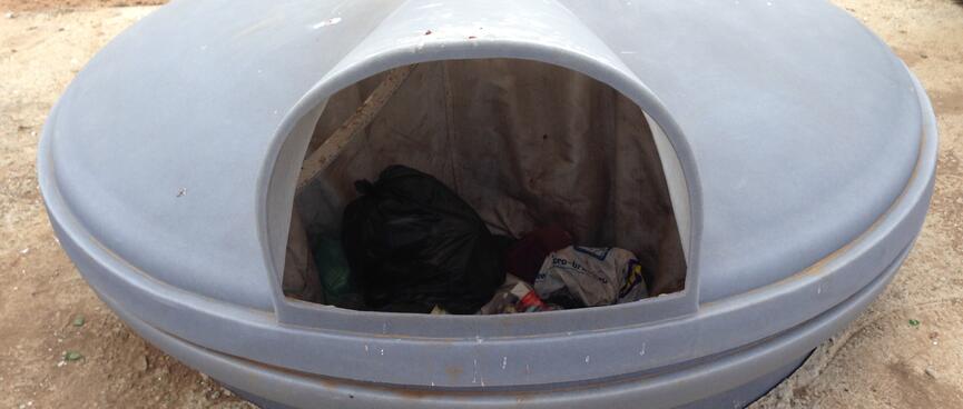 A large, covered saucer-shaped rubbish bin.