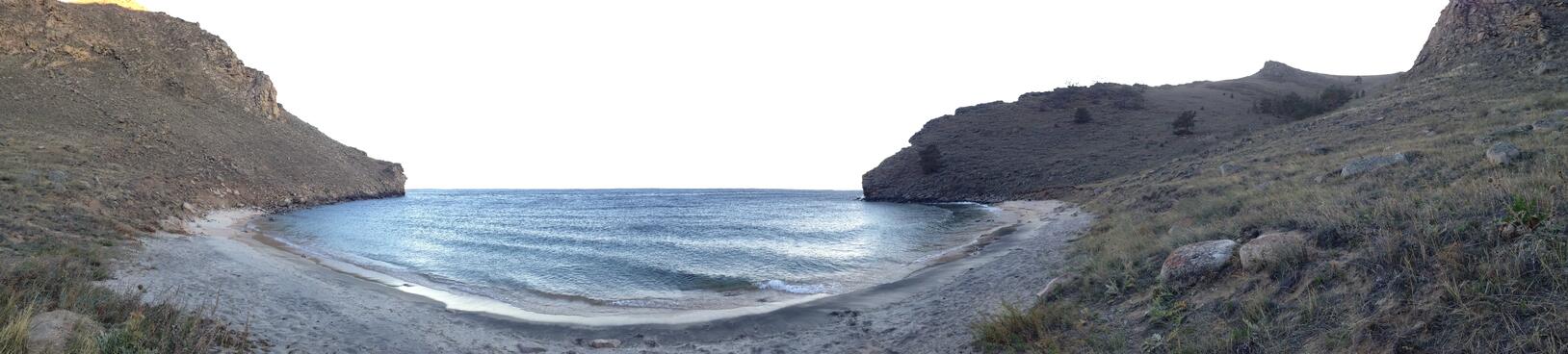 Waves ripple within the sandy bay.