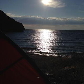 A bright sun reflects in the ocean.