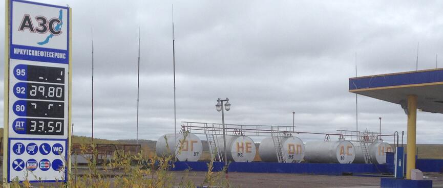 A row of storage tanks containing different types of gasoline.
