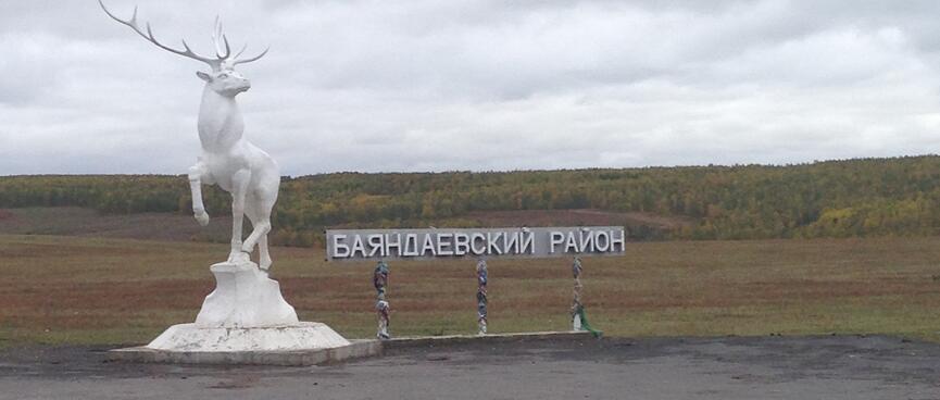 A proud white reindeer stands on a stone plinth.