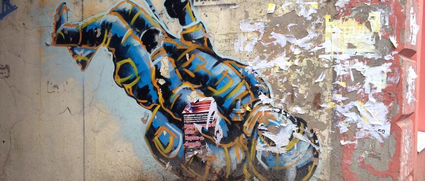A spray painted cosmonaut shares a wall with promotional flyers.