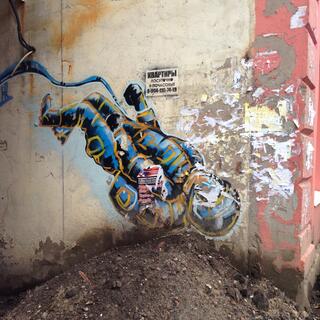 A spray painted cosmonaut shares a wall with promotional flyers.