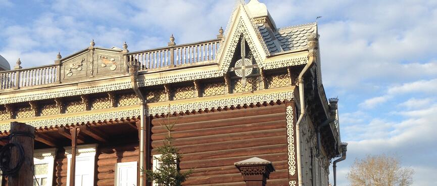 A two storied wooden building with ornate detailing.