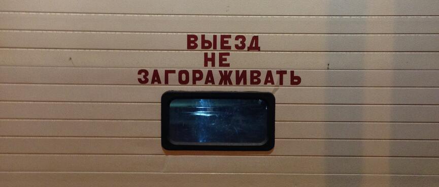 A small rectangular window in the middle of a wide roller door.