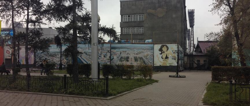A wall is covered in city paintings and graffiti.