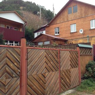 A fence is decorated with diagonal wooden slats.