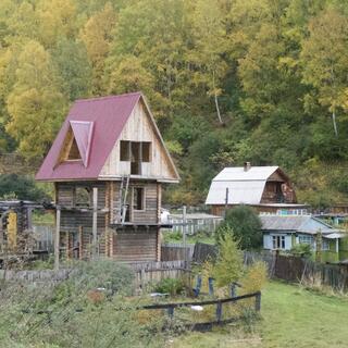 A three story wooden house reminiscent of a childrenʼs tree house.