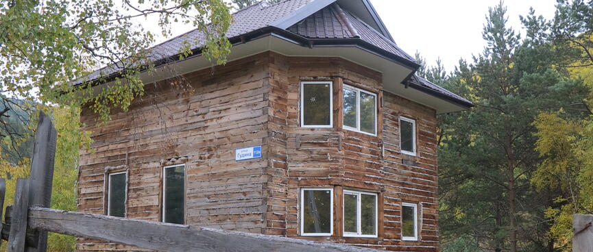 A large house constructed from interlocking wooden beams and roof sections.