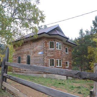 A large house constructed from interlocking wooden beams and roof sections.