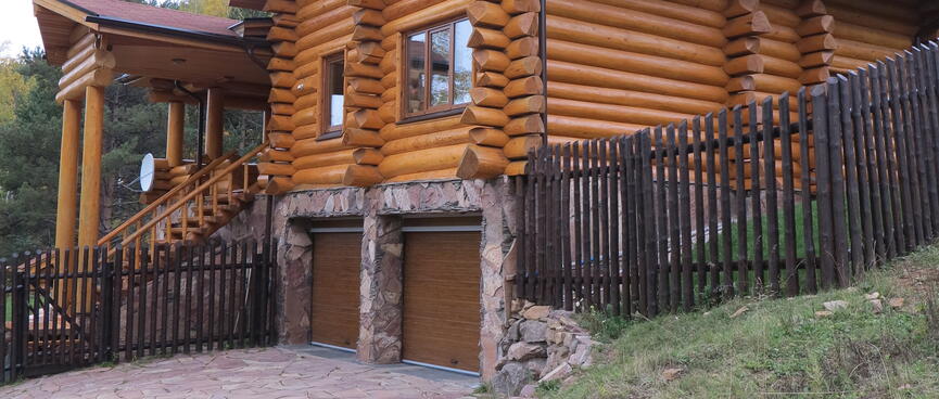 Double garage below a large log house.