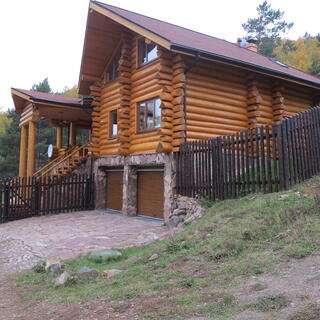 Double garage below a large log house.