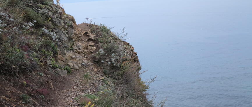A narrow path hugs the side of a steep bank.