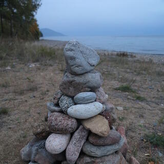 Large rocks are stacked up on the beach.