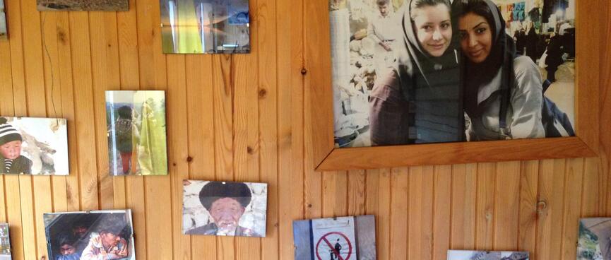 Travel photos on the hostel wall.