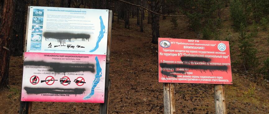Black spray paint hides rules on printed sign boards.
